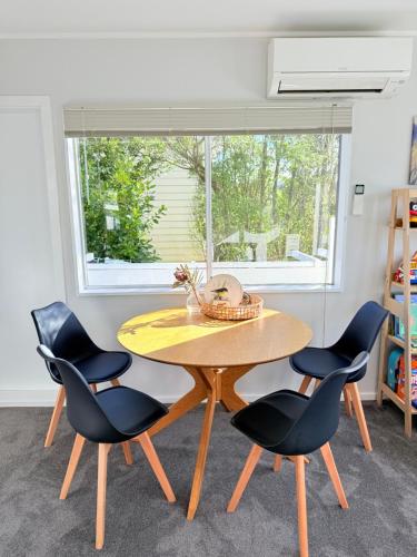 une table et des chaises dans une pièce avec une fenêtre dans l'établissement Renovated Entire 2BR Flat, Comfort, Scenic Views, Free Parking & 10 min to Ferry, à Wellington