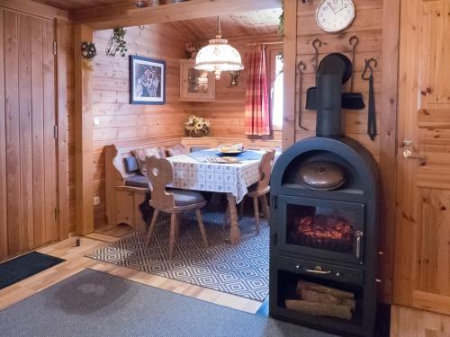 a living room with a stove and a table at Ferienhaus Nr 5, Typ A, Feriendorf Jägerpark, Bayerischer Wald in Prackenbach