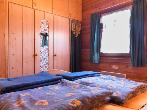 two beds in a room with wooden walls and a window at Ferienhaus Nr 5, Typ A, Feriendorf Jägerpark, Bayerischer Wald in Prackenbach