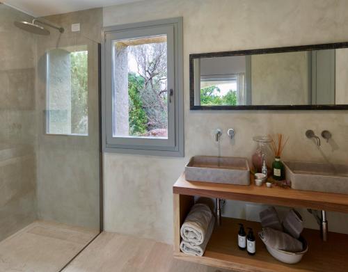 a bathroom with a sink and a shower with a mirror at Cascioni Eco Retreat in Arzachena