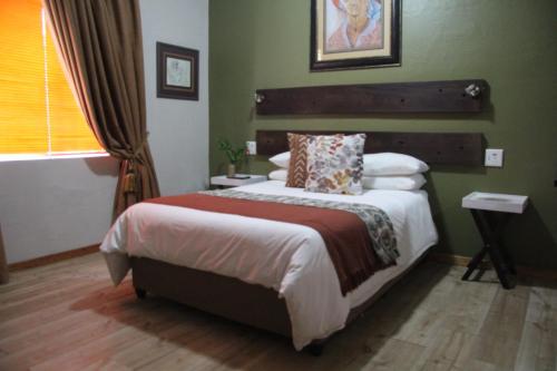 a bedroom with a bed in a green room at AshTree GuestHouse in Hanover