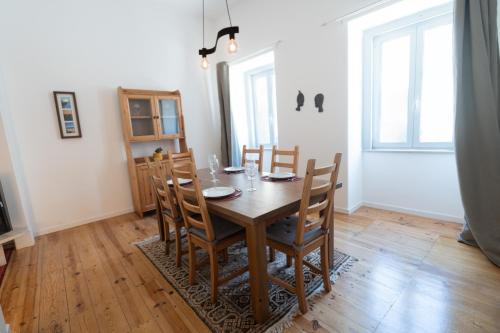 a dining room with a wooden table and chairs at Alfarrobeira House in Cascais