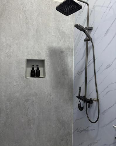 a shower in a bathroom with two bottles on a wall at Lux Hotel Mathiveri in Mathiveri