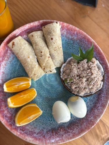 Un plato de salsa con huevos, galletas y rodajas de naranja. en Lux Hotel Mathiveri, en Mathiveri