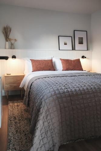 a bedroom with a large bed with red pillows at The Crow's Nest Skye in Kensaleyre