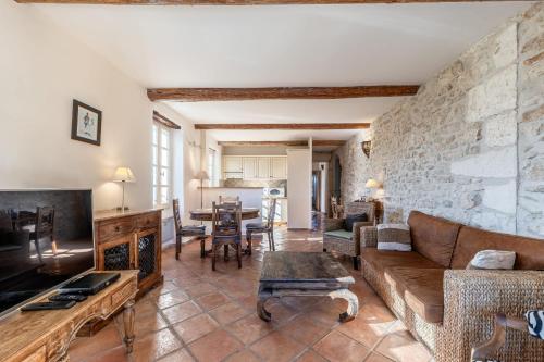 a living room with a couch and a tv at Le Lieutenant in Bonnieux
