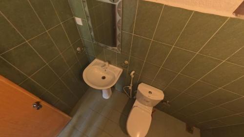 Un baño pequeño con inodoro y lavabo. en Asanka Surf Hostel & food, en Midigama East