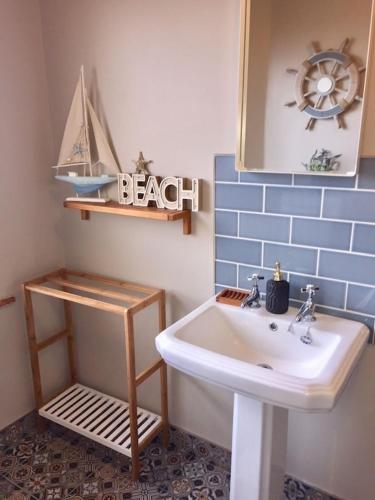 a bathroom with a sink and a boat on the wall at Ballyboe Cottage in Dunfanaghy