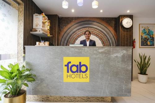 un PDG d'hôtels ioo se tient derrière un comptoir de réception dans l'établissement FabHotel Atithi Residency I - Nr BKC, à Mumbai