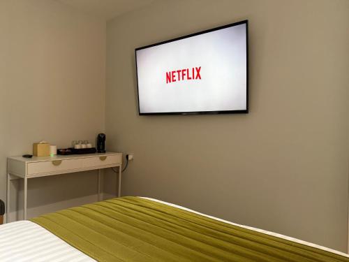 a television hanging on a wall in a bedroom at Sarah Hotel in Harwich