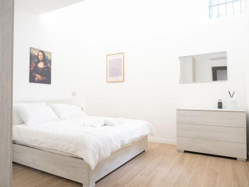 - une chambre blanche avec un lit blanc et une commode dans l'établissement suite boutique viale assunta 90, à Cernusco sul Naviglio