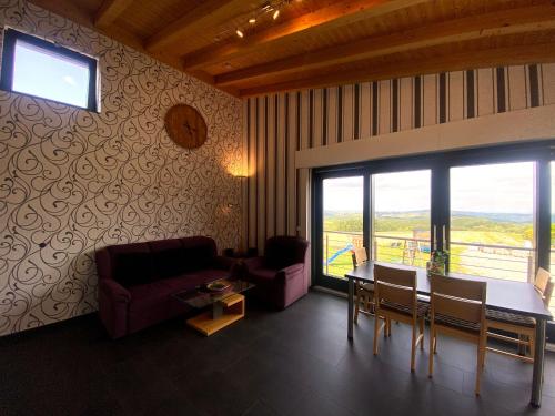 Una sala de estar con un sofá y una mesa con sillas. en Wohnung In Schmidt Mit Grill Und Garten, en Nideggen