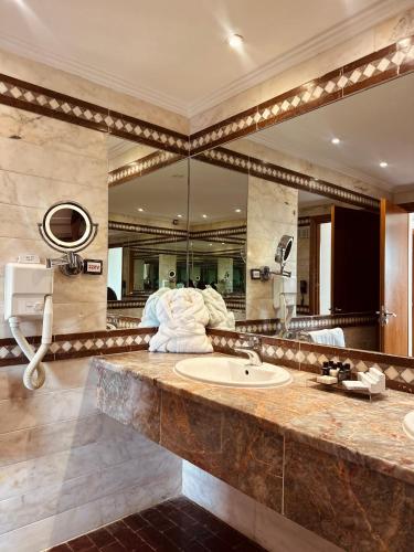 a bathroom with a sink and a large mirror at Tunis Grand Hotel in Tunis