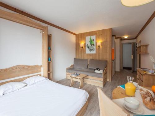 a bedroom with a bed and a couch and a table at Charmant studio centre Val d'Isère - Balcon vue montagne - in Val dʼIsère