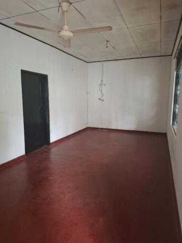 an empty room with a red floor and a ceiling at Tankiwattha Lodge in Wattala