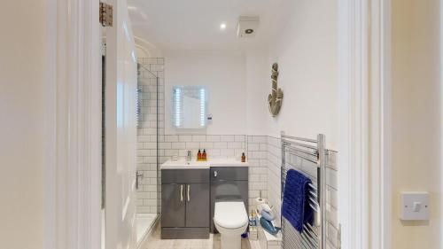 Un baño blanco con inodoro y lavabo. en Finelia House, en Topsham