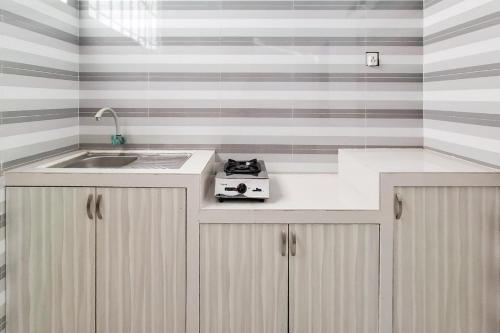 a kitchen with a sink and a counter top at RedDoorz Syariah near Tanjung Pinang City Center in Tanjung Pinang 
