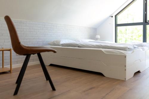 una camera da letto con un letto bianco e una sedia di Na.Zadkach a Klon