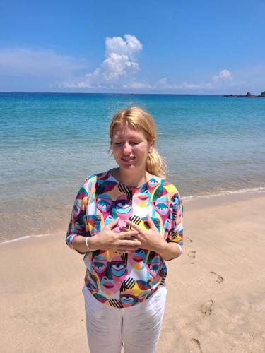 a woman standing on the beach looking at her cell phone at Beach life long beach resort in Trincomalee