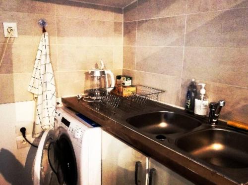 a kitchen with a sink and a washing machine at Minimaliste 10min Futuroscope & Cœur de Poitiers in Buxerolles