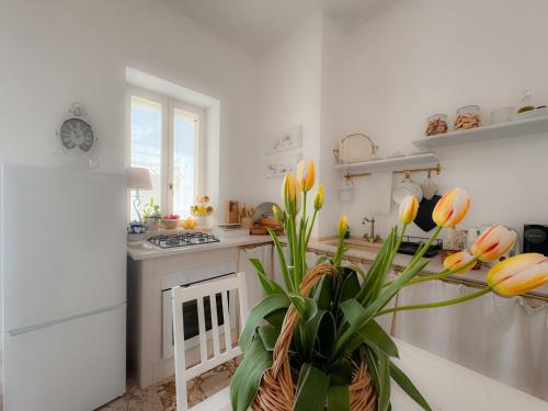 a white kitchen with a vase with flowers in it at Eldoh in Bernalda