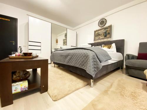 a bedroom with a bed and a table and a chair at Coresi Escape Studio in Sînpetru