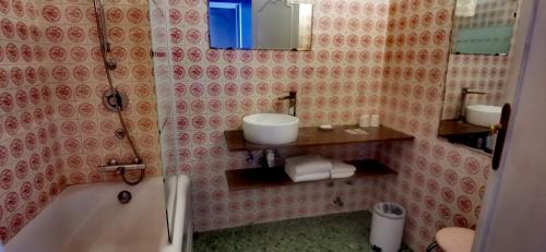 a bathroom with a sink and a tub and a mirror at Hotel du Commerce Chez Stéphane in Roumazières