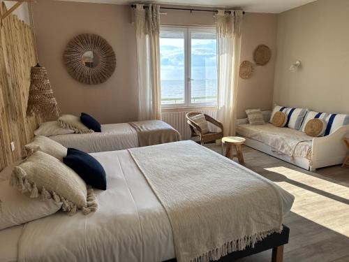 a bedroom with two beds and a couch and a window at Acadie Saint Victor - Hôtel restaurant -Face mer- Châtelaillon plage in Châtelaillon-Plage