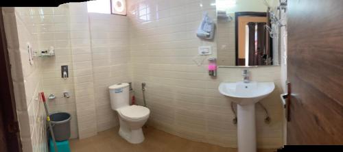 a small bathroom with a toilet and a sink at Sita Hotel & Cottage, Manali - A Boutique Wellness Hotel in Manāli