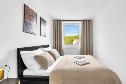 a white bedroom with a bed and a window at Cloud Apartment in Koliba