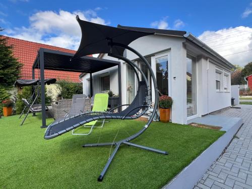 a swing set on the grass in a yard at Gold Frog Apartman in Abaliget