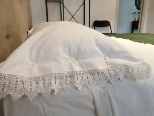 Una cama blanca con una falda de cama blanca encima en Suite Petit, en Vairano Scalo
