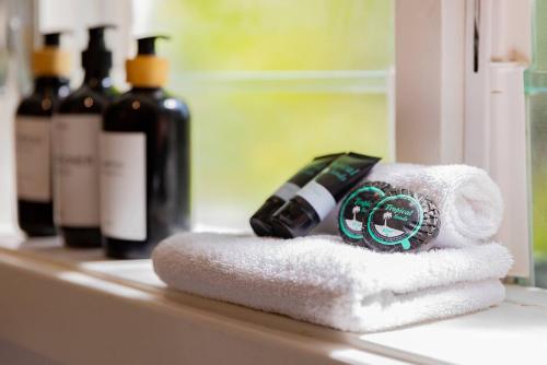 a bathroom counter with a towel and bottles of wine at Fairy Nook - Charming Granny Flat with Shared Garden in Mayfield