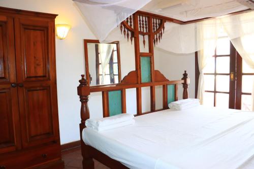 a bedroom with a canopy bed with white sheets at Vera Cruiz one bedroom CBD in Malindi