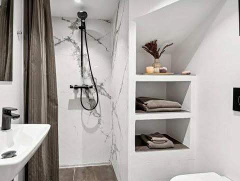 a bathroom with a shower and a toilet and a sink at Østerbrogade 49 in Holstebro