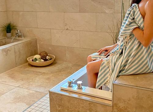 ツィングストにあるWellness-Residenz Wohnung 18の浴室のベンチに腰掛けた女性