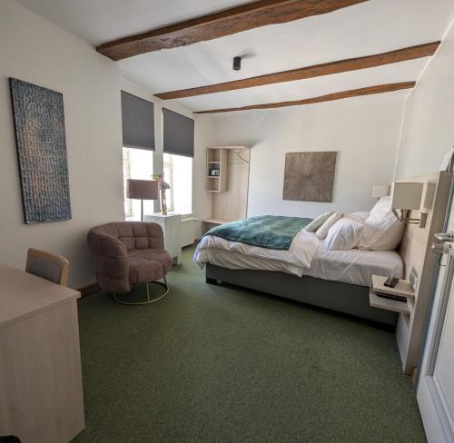 ein Schlafzimmer mit einem Bett und einem Stuhl in der Unterkunft Altes Rathaus Kassel-Wolfhagen in Wolfhagen