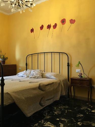 een slaapkamer met een bed met rode papavers aan de muur bij Casa Jacopo in Diano Marina