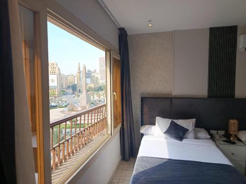 a hotel room with a bed and a large window at Lotus Al-Tahrir hotel in Cairo