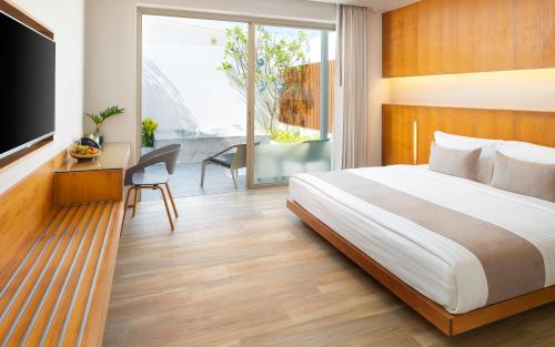 Un dormitorio con una cama, un escritorio y un televisor. en Explorar Koh Samui - Adults Only Resort and Spa, en Mae Nam