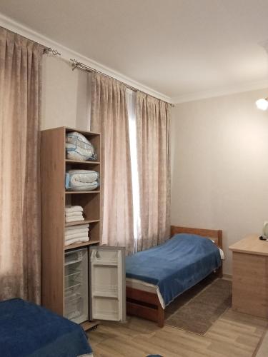 a bedroom with a bed and a book shelf at Сарканд in Sarqan