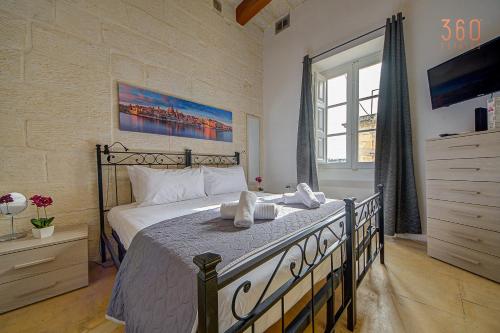 a bedroom with a large bed and a large window at Suite Victory Beautiful fully equipped 2BR Townhouse by 360 Estates in Birgu