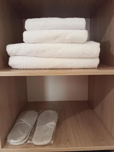 a shelf with white towels and folded towels at Сарканд in Sarqan