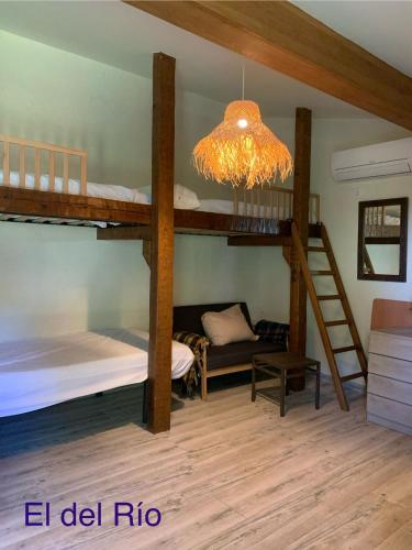 a room with two bunk beds and a chandelier at CASA PARVATHI CANDELEDA in Candeleda