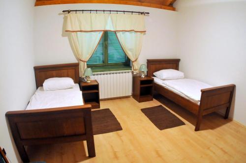 1 dormitorio con 2 camas y ventana en Guest accomodation Lovacka kuca, en Grdak