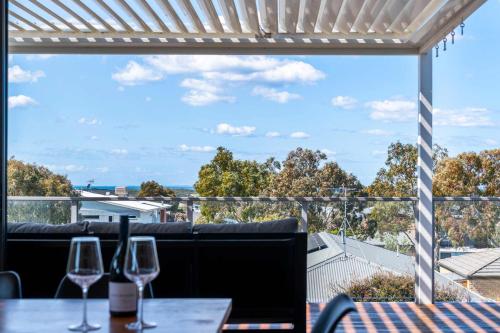 a view from the balcony of a restaurant with wine glasses on a table at Spacious Seaview Family Getaway in Torquay
