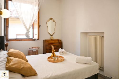 a bedroom with a bed with white sheets and a window at Inn Pisa Rentals 2 - Rustic Romantic Pisa Flat in Pisa