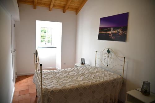 a bedroom with a bed and a window at Casa Isqueiro in Cela