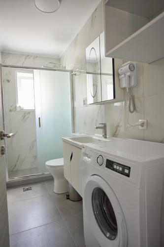 a bathroom with a washing machine and a toilet at ChioSmart Town Apartments in Chios