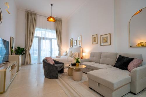 a living room with a couch and a tv at Elegant Studio Oasis - Yas Island Chic Retreat in Abu Dhabi